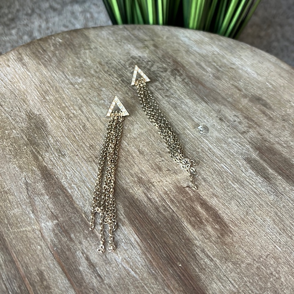 Gold statement earring with triangle and chains.